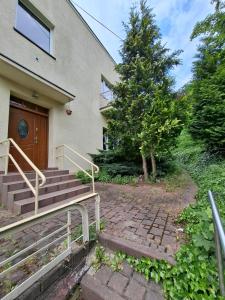 a house with stairs and a tree in front of it at Pokoje na lato Gdynia in Gdynia