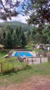 a swimming pool in a yard with a fence at Camping montagne in Camurac