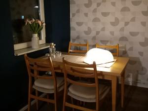 a dining room table with four chairs and a table with flowers at Ferienwohnung Prignitzhof in Plattenburg