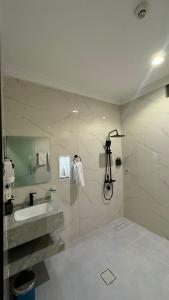 a bathroom with a sink and a shower at زون آفينيو للشقق المخدومة Zone avenue in Hafr Al-Batin