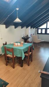 a dining room table with chairs and a blue ceiling at B&B Sella Klancic in San Pietro al Natisone