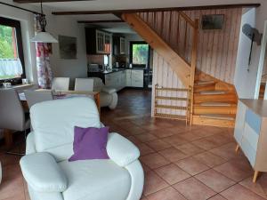 a living room with a white couch and a staircase at Ferienhaus Rümdriewer in Pruchten