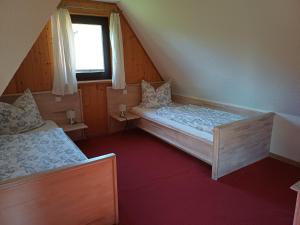 two beds in a small room with a window at Ferienhaus Rümdriewer in Pruchten