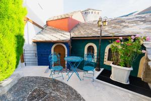 a small house with chairs and a table on a patio at Ali Baba Apartment in Mostar
