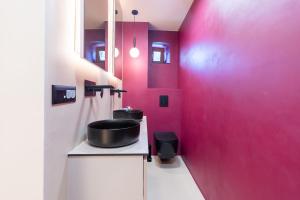 a bathroom with a sink and a pink wall at Ali Baba Apartment in Mostar +29 photos