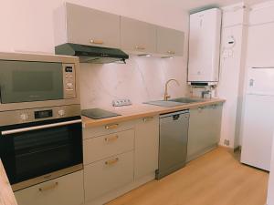 a kitchen with a microwave oven and a sink at Les pieds dans l'eau in Mèze