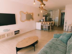 a living room with a couch and a table at Les pieds dans l'eau in Mèze