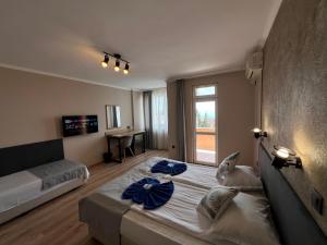 a bedroom with two beds and a large window at Family Hotel Milev in Sveti Vlas