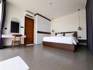 a bedroom with a bed and a desk and a chair at Hey-Sola Bali ,3BR Luxury Private Villa Near Canggu in Dalung