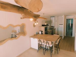 a kitchen with a wooden table and a mirror on the wall at Les pieds dans l'eau in Mèze +10 photos