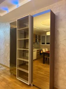 a large glass cabinet in a room with a kitchen at Swimming pool apartment in Budva +16 photos