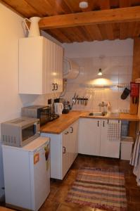 eine kleine Küche mit weißen Schränken und einem Waschbecken in der Unterkunft Drevenička Jakubko in Terchová