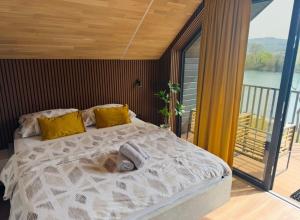 a bedroom with a bed with yellow pillows and a balcony at Apartments MLIN in Bihać +112 photos
