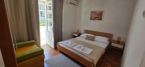 a bedroom with a bed and a chair and a window at Bascarsija in Ulcinj