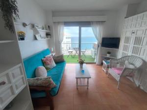 a living room with a couch and a view of the ocean at Atico estudio en 1°linea Almuñecar in Almuñécar