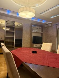 a dining room with a red table and chairs at Swimming pool apartment in Budva