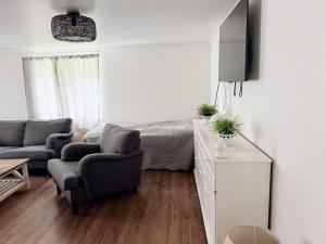a bedroom with a bed and a couch and a chair at 4 star holiday home in BRO in Bro