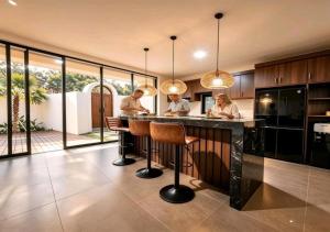 a kitchen with two people standing at a bar at Hey-Sola Bali ,3BR Luxury Private Villa Near Canggu in Dalung