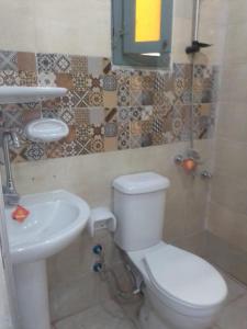 a bathroom with a white toilet and a sink at ادفو 35سرير ثلاثي in Alexandria