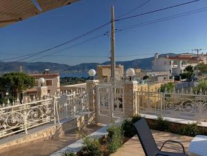 a balcony with a white fence and a chair at stavros house byzarkco in Porto Rafti