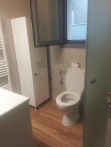 a bathroom with a white toilet with a window at stavros house byzarkco in Porto Rafti +27 photos