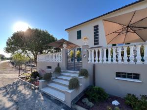 a white house with a staircase and an umbrella at Villa Scarpino in Massignano