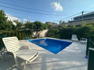 a white chair next to a swimming pool at Pool Villa Sarajevo in Sarajevo