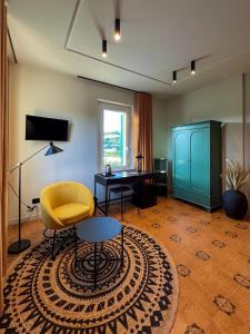 a living room with a yellow chair and a desk at Villa Scarpino in Massignano