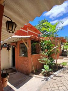 a brick house with a tree in front of it at Hostel Sossego do Garças in Barra do Garças
