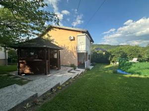 a building with a gazebo next to a yard at Pool Villa Sarajevo in Sarajevo