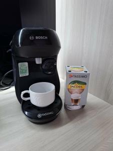 a coffee maker with a cup and a box on a counter at Apartament Rekiny na Wakacjach - Aquapark Reda 200m - Prywatny Parking in Reda +4 photos