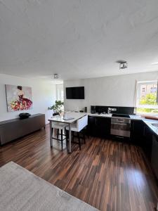 a living room with a table and a kitchen at Ferienwohnung Homburger - Immenstaad am Bodensee in Immenstaad am Bodensee +19 photos