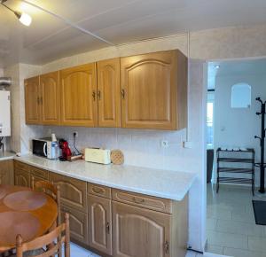 a kitchen with wooden cabinets and a table in it at séjour en Alsace in Ingersheim