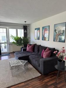 a living room with a gray couch and pink pillows at Ferienwohnung Homburger - Immenstaad am Bodensee in Immenstaad am Bodensee