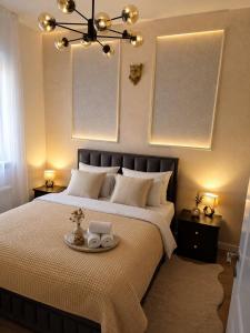 a bedroom with a bed with a tray with towels on it at VukAs in Palić