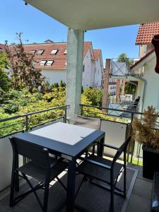 a table and chairs on a balcony with a view at Ferienwohnung Homburger - Immenstaad am Bodensee in Immenstaad am Bodensee