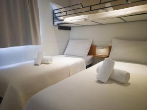 two beds in a room with two white beds at Lavender Mobile Houses in Pakoštane