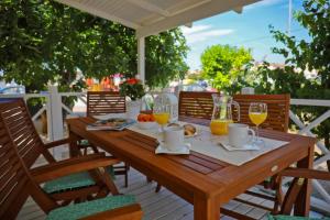 a wooden table with a breakfast of oranges and juice at Lavender Mobile Houses in Pakoštane