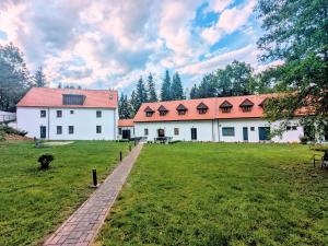 a large white building with a red roof at Penzion Na bezu in Drahonice