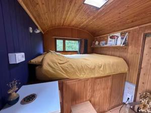 a bedroom with a bed in a wooden room at Roulotte in Huismes