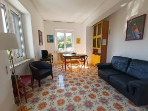 a living room with a couch and a table at Villa Rosa Rooms in Ischia Town