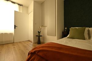 a bedroom with a bed and a vase of flowers at Le Cocon de Pommard in Pommard