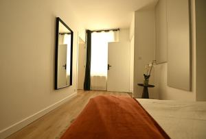 a bedroom with a bed and a mirror on the wall at Le Cocon de Pommard in Pommard +7 photos