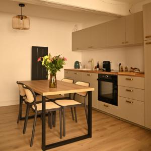 a kitchen with a table with chairs and a vase of flowers at Le Cocon de Pommard in Pommard