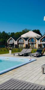 a house with a swimming pool and an umbrella at Morze Na Zawsze in Rewal