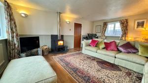 a living room with a couch and a fireplace at The Coach House in Braunton