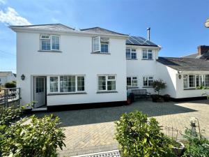 a white house with a patio in front of it at The Coach House in Braunton