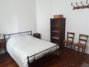 a bedroom with a bed and two chairs at Vincennes - Parisian appartment in Vincennes