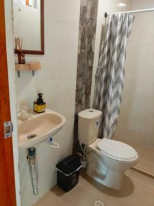 a bathroom with a toilet and a sink at Hostal Nomadax Tayrona in El Zaino