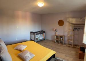 a bedroom with a yellow bed and a shelf at séjour en Alsace in Ingersheim
